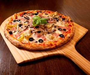 Capricciosa Pizza served with mozzarella, tomato sauce, ham, mushrooms, black olives, artichokes, basil.