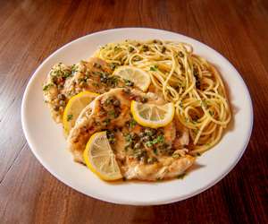 Chicken Picatta, served with a side of spaghetti in a lemon caper sauce