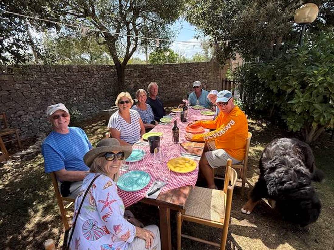 Tour group enjoying an alfresco meal in Italy.